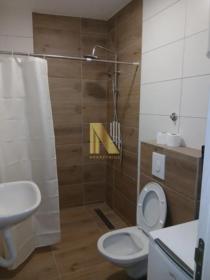 Moderno opremljeno kupatilo sa tuš kabinom i WC šoljom.