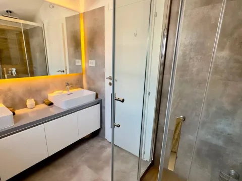 Modern bathroom with a sink and a shower cabin. - image 11