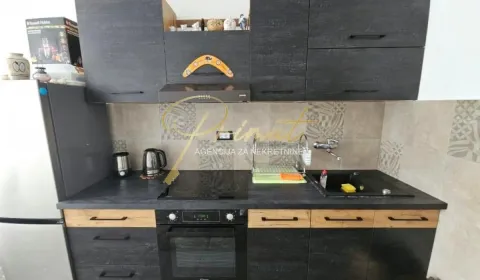 Small kitchen with dark cabinets, a sink, and a built-in oven. - image 7