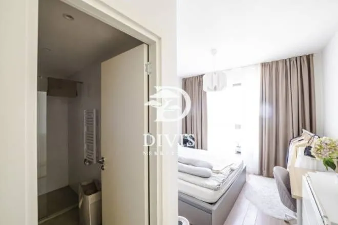 View from the hallway into the bedroom with a bed and en-suite bathroom.