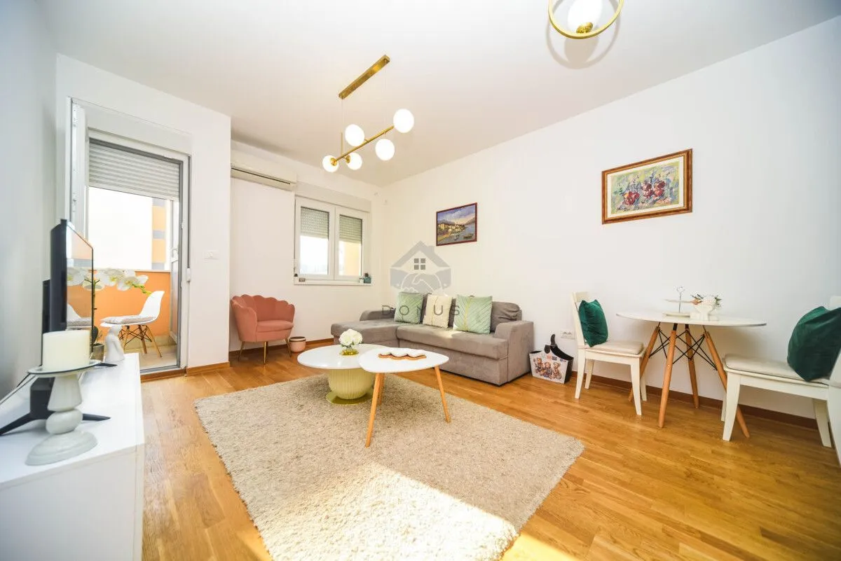 Furnished living room with a sofa set, dining table, and access to the terrace.