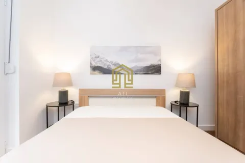 Furnished bedroom with a double bed, bedside tables, and a wardrobe. - image 8