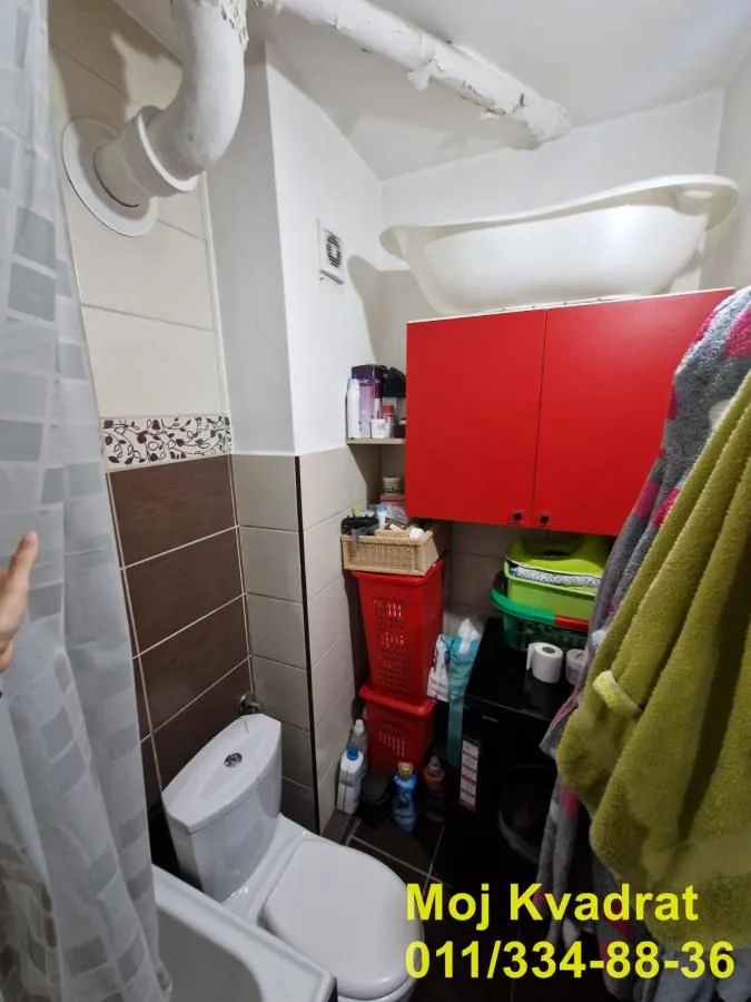 Manje kupatilo sa WC šoljom, ugradnim elementima i kadom.