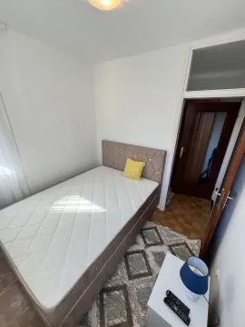Mala spavaća soba sa jednim krevetom i noćnim ormarićem. - image 5