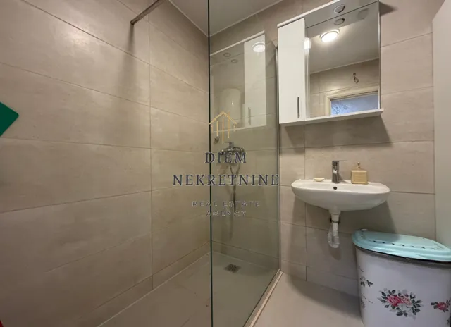 Modernly equipped bathroom with a shower cabin and a washbasin.