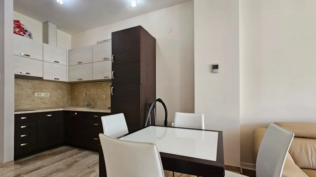 Small kitchen with a dining table and chairs connected to the living room.