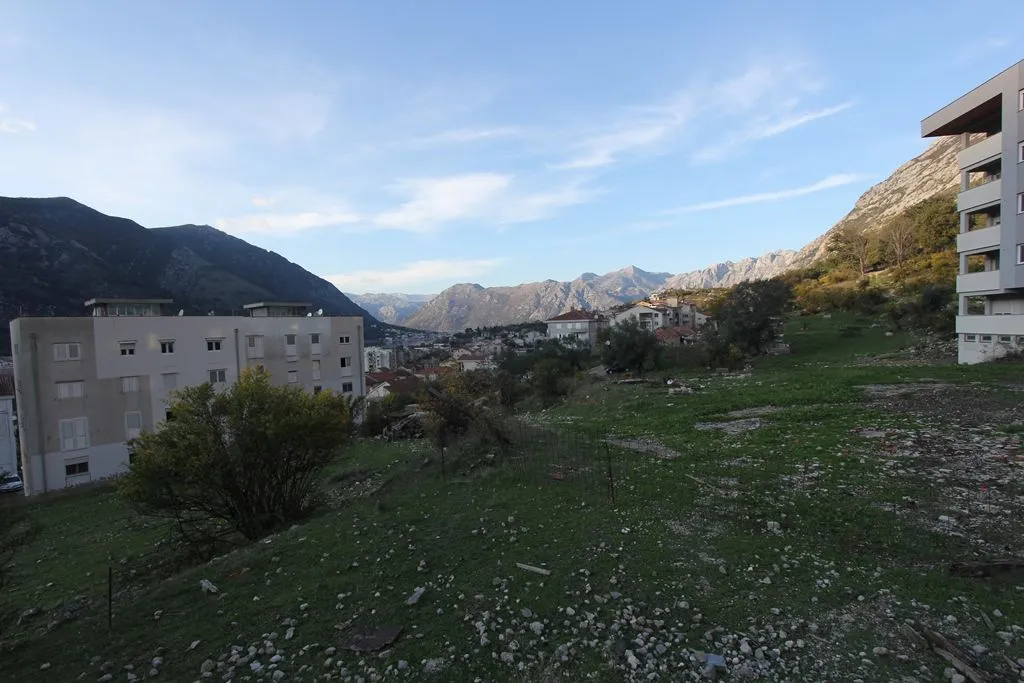 Pogled na zemljište i okolne zgrade sa planinama u pozadini.