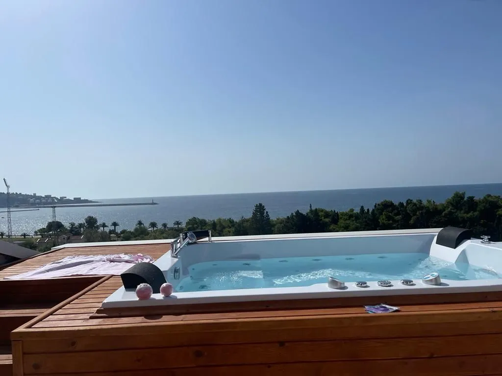 Terrace with a hot tub and sea view.