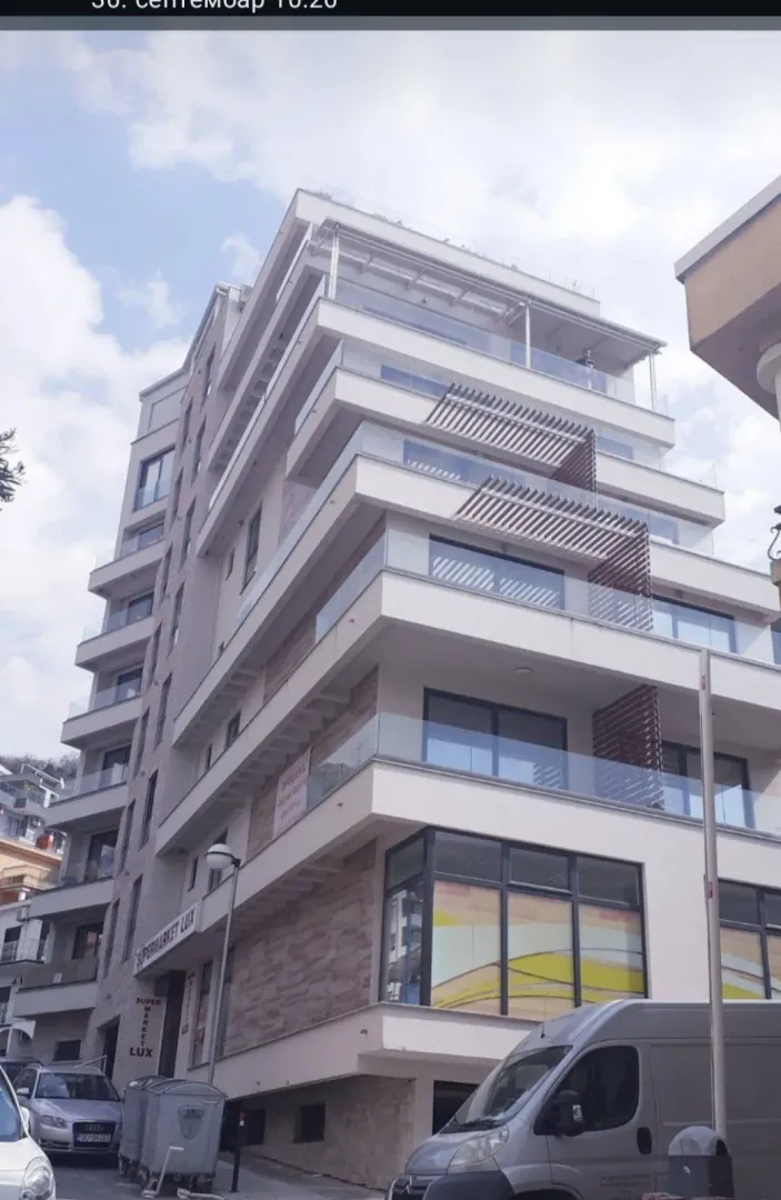 Exterior view of a modern multi-story residential building with balconies.