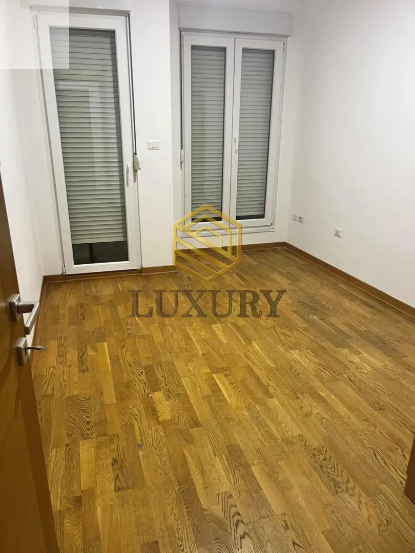 Empty room with parquet flooring and white walls.