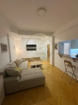 Dnevna soba sa garniturom, TV-om i šankom koji je povezuje sa kuhinjom. - image 5