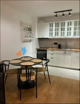 Kuhinja sa belim elementima i trpezarijskim stolom sa crnim stolicama. - image 4