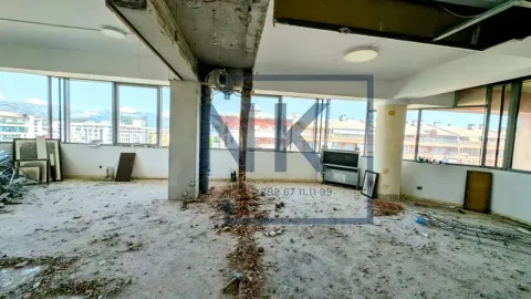 A view of a large space under construction with large windows and city views. - image 3