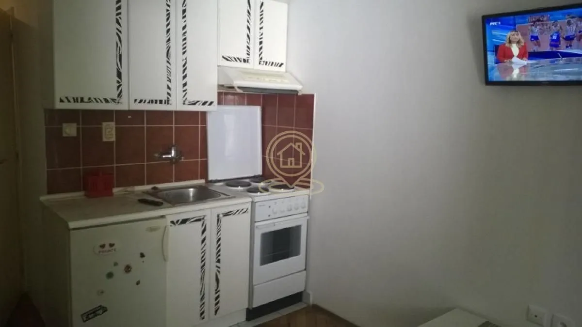 Small kitchen with white cabinets and a stove.