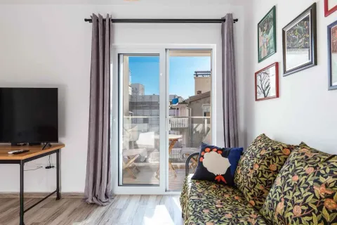 Living room with a sofa, TV, and access to the terrace. - image 17