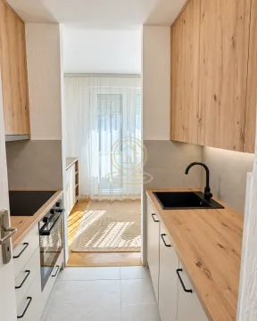 Moderna uska kuhinja sa drvenim elementima i ugrađenim aparatima. - image 10