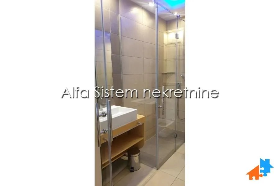 Modernly equipped bathroom with a washbasin and a shower cabin.