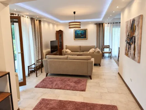 Spacious living room with a sofa set, TV, and dining area in the background. - image 2
