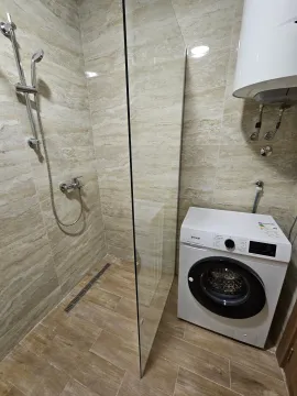 Moderno opremljeno kupatilo sa tuš kabinom i veš mašinom. - image 5