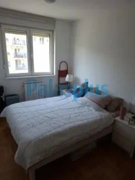Nameštena spavaća soba sa bračnim krevetom, noćnim stočićima i prozorom. - image 6