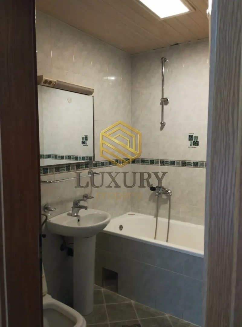 Manje kupatilo sa umivaonikom, kadom i ogledalom.