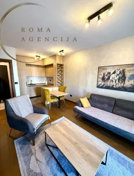 Modern living room with a sofa, coffee table, and a dining area with a kitchen in the background. - image 5