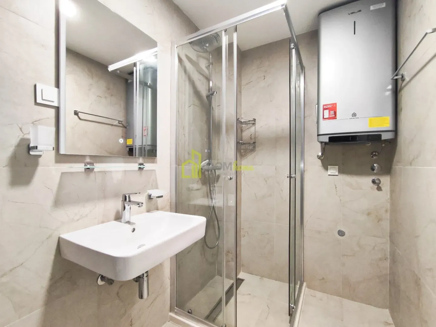 Bathroom equipped with a washbasin, mirror, and shower cabin.