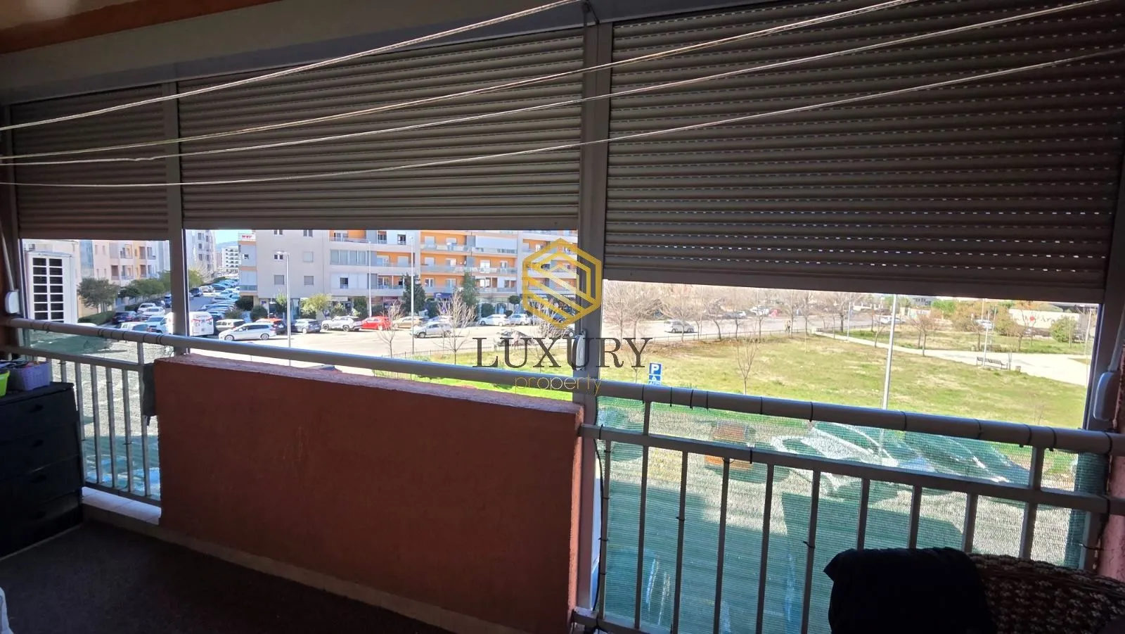 Natkrivena terasa sa pogledom na parking i naselje.