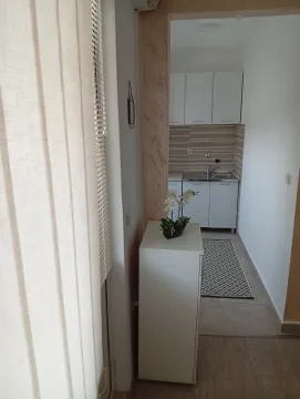 Pogled na malu i funkcionalnu kuhinju sa bijelim elementima kroz hodnik. - image 8