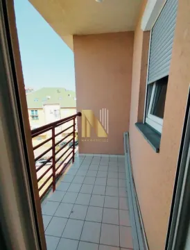 Namještena i popločana terasa sa metalnom ogradom i pogledom na okolne zgrade. - image 13
