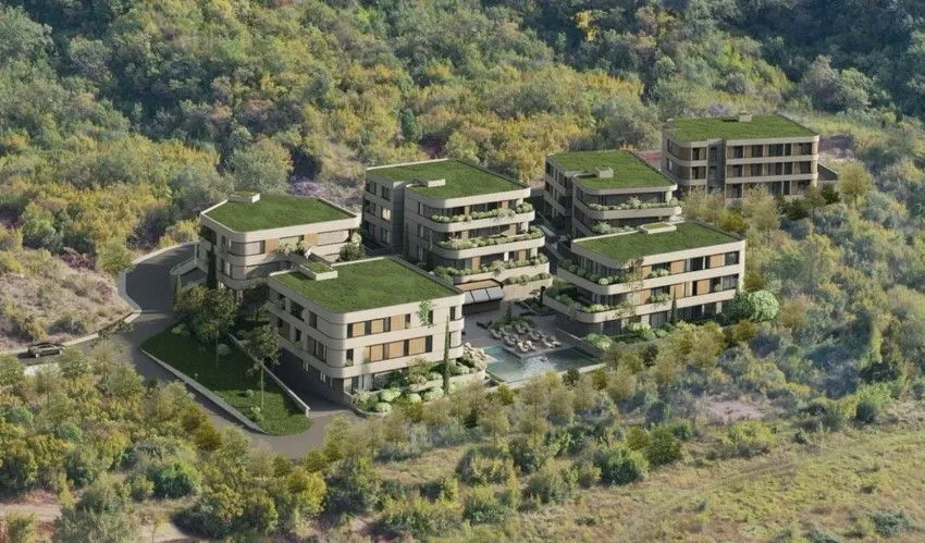Pogled iz ptičje perspektive na kompleks modernih zgrada sa zelenim krovovima u prirodi.
