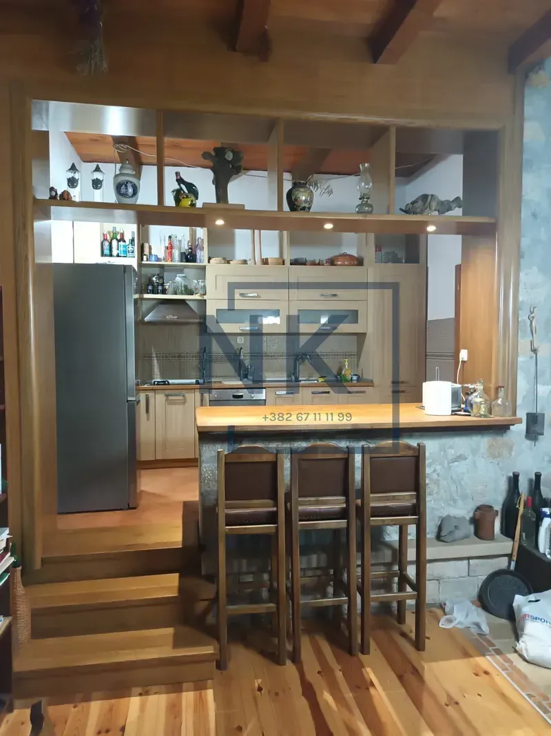 Kuhinja sa šankom i drvenim elementima u rustičnom stilu.