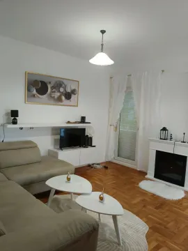 Bright living room with sofa, fireplace, and parquet flooring. - image 2