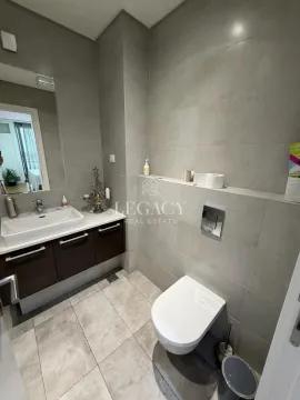 Moderno kupatilo sa umivaonikom, ugradnom WC šoljom i sivim pločicama. - image 8