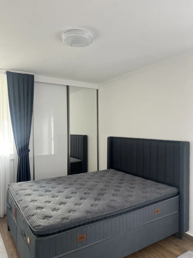 Bright bedroom with a large bed and a wardrobe.