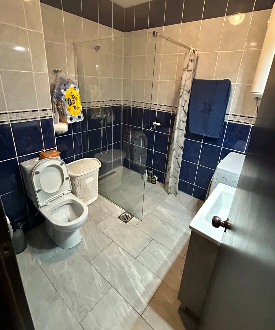 Manje kupatilo sa tuš kabinom, WC šoljom i umivaonikom.
