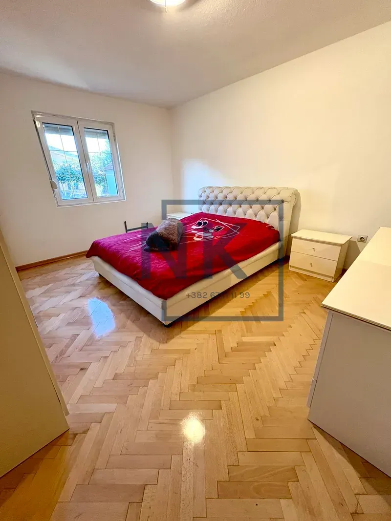 Bedroom with a double bed, nightstands, and parquet flooring.