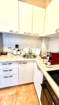 View of a small kitchen with a sink, countertop, and kitchen units. - image 2