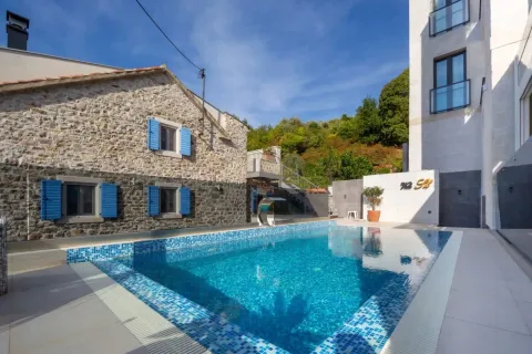 Exterior with a swimming pool and a stone house. - image 13