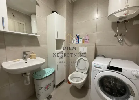 Small bathroom with a sink, toilet, cabinet, and washing machine. - image 11