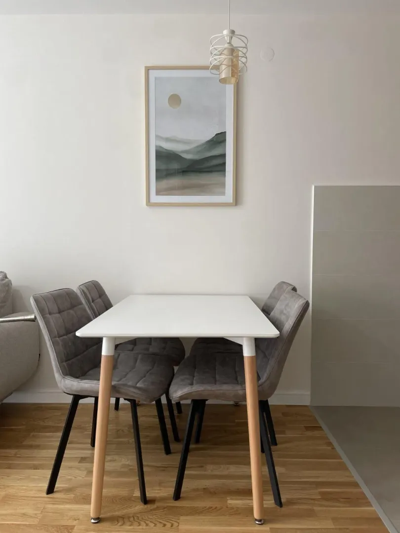Dining table with four grey upholstered chairs.