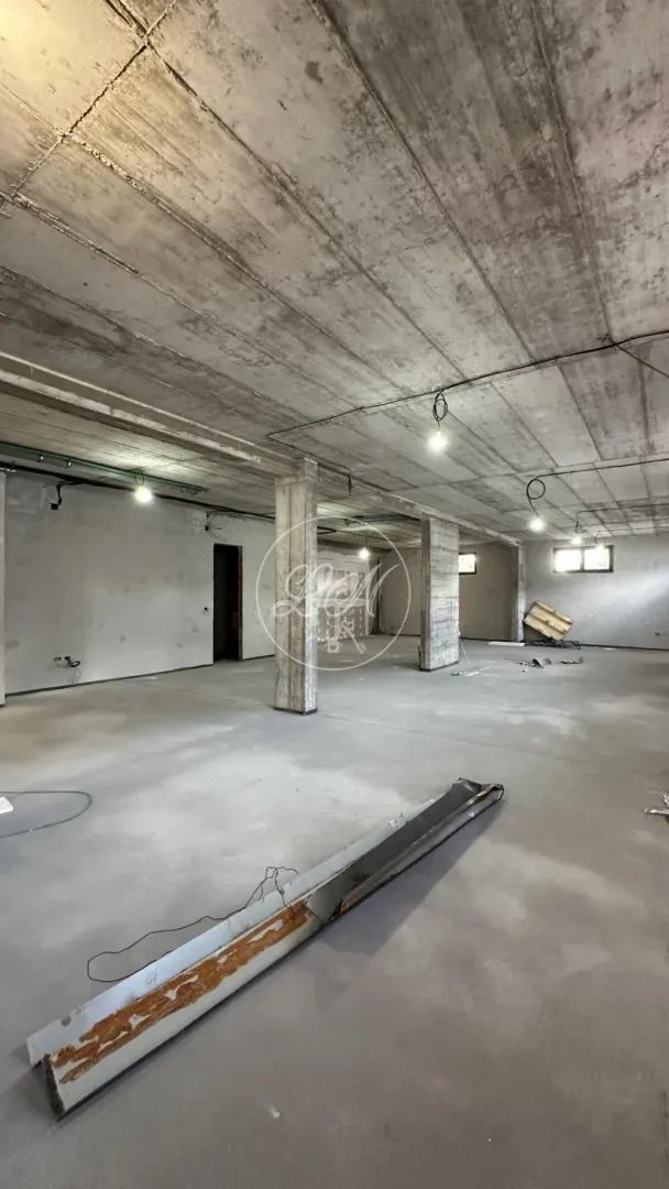 Unfinished space under construction with concrete pillars and ceiling.