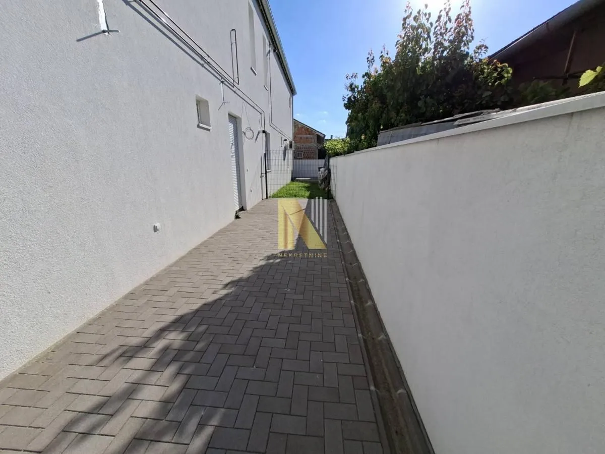 Paved courtyard and passage beside the house.