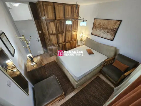 Namještena spavaća soba sa velikim bračnim krevetom, drvenim ormarom i foteljom. - image 4