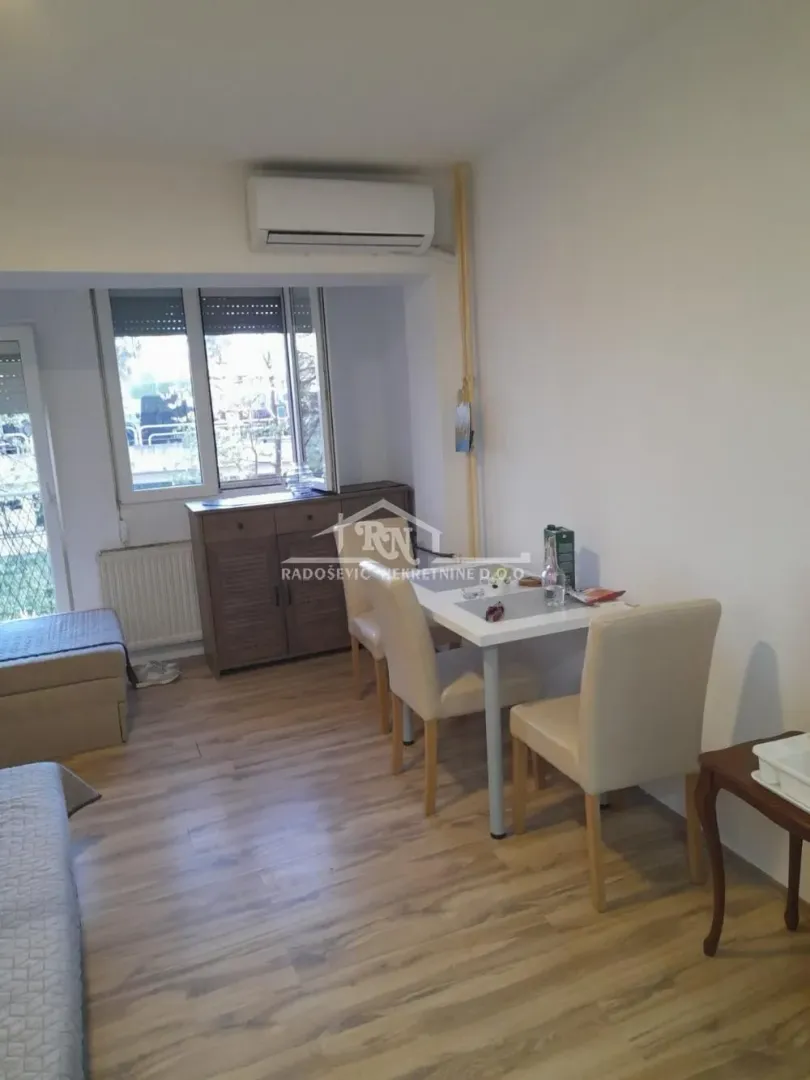 Living room with a dining table and air conditioning.