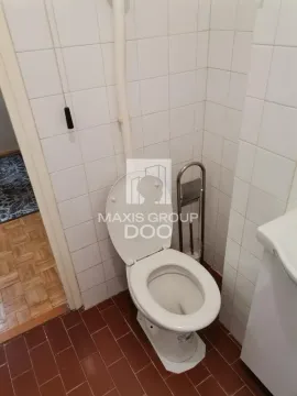 Manje kupatilo obloženo belim pločicama sa toaletom. - image 9