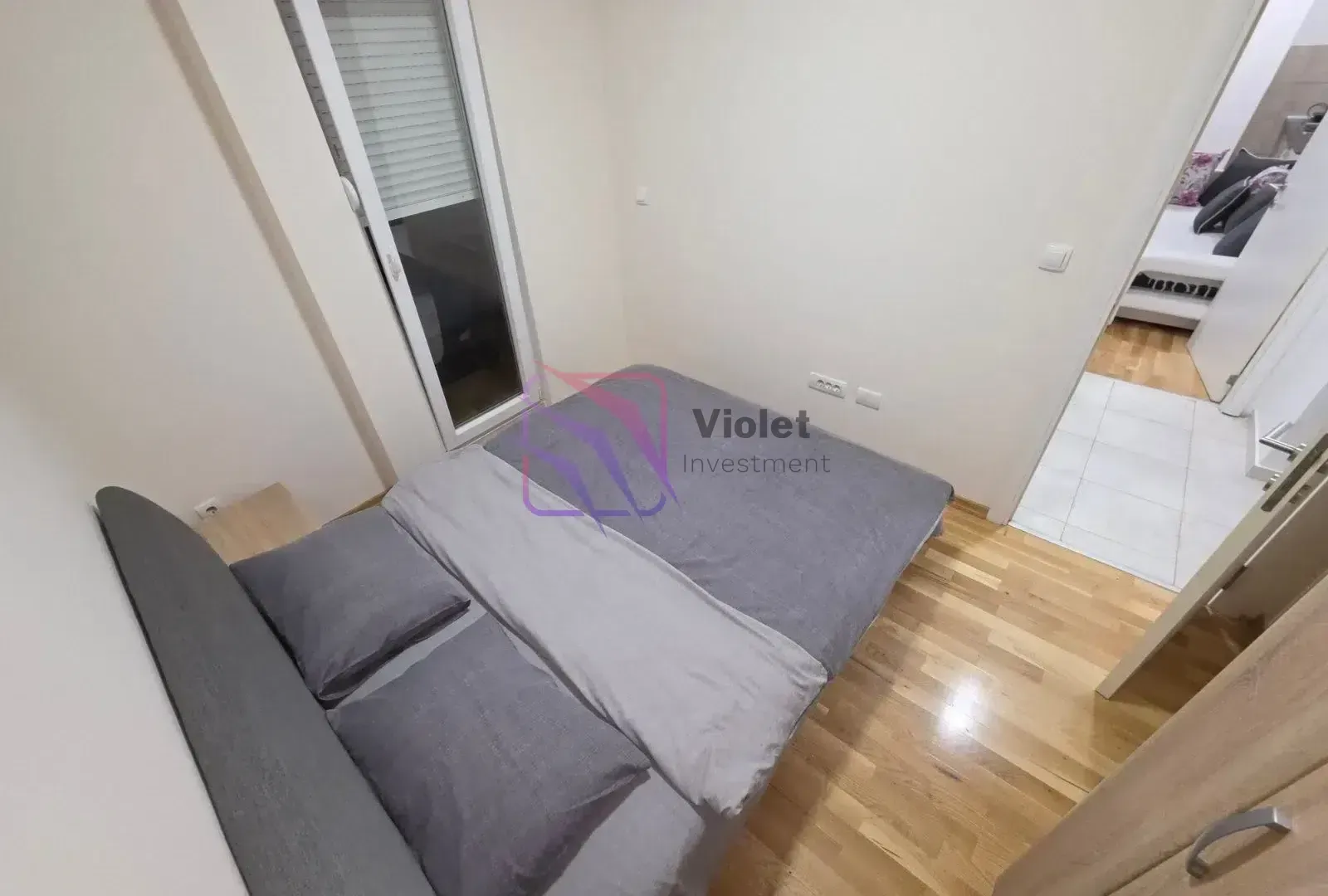 Smaller bedroom with a double bed and parquet flooring.