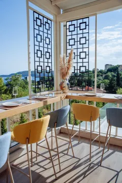 Enclosed terrace with a bar table, chairs, and a sea view. - image 9