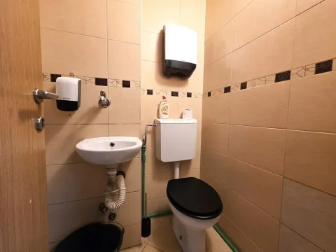 Small bathroom with a sink and toilet tiled in ceramic tiles. - image 6