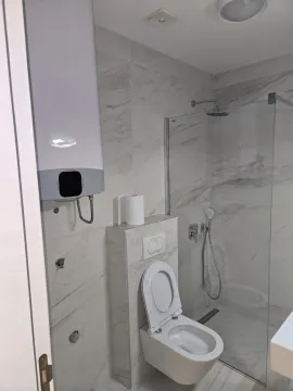 Bright bathroom with a shower cabin and toilet. - image 4